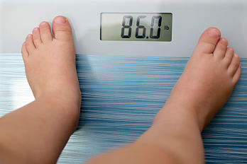 Overweight child on weighing machine