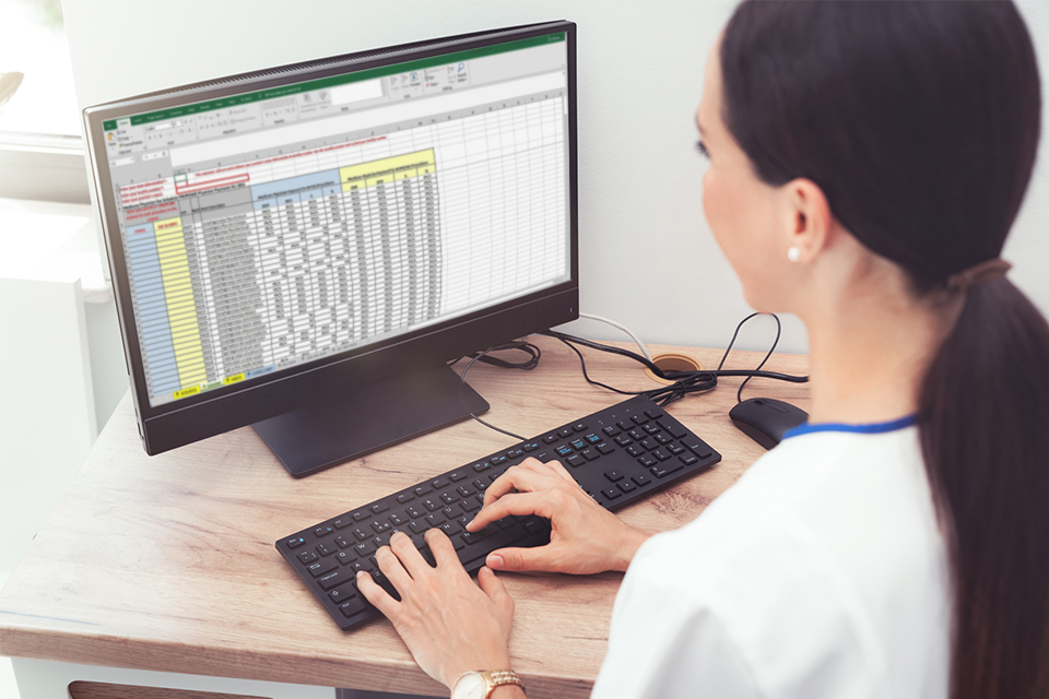 Woman typing in spreadsheet on computer