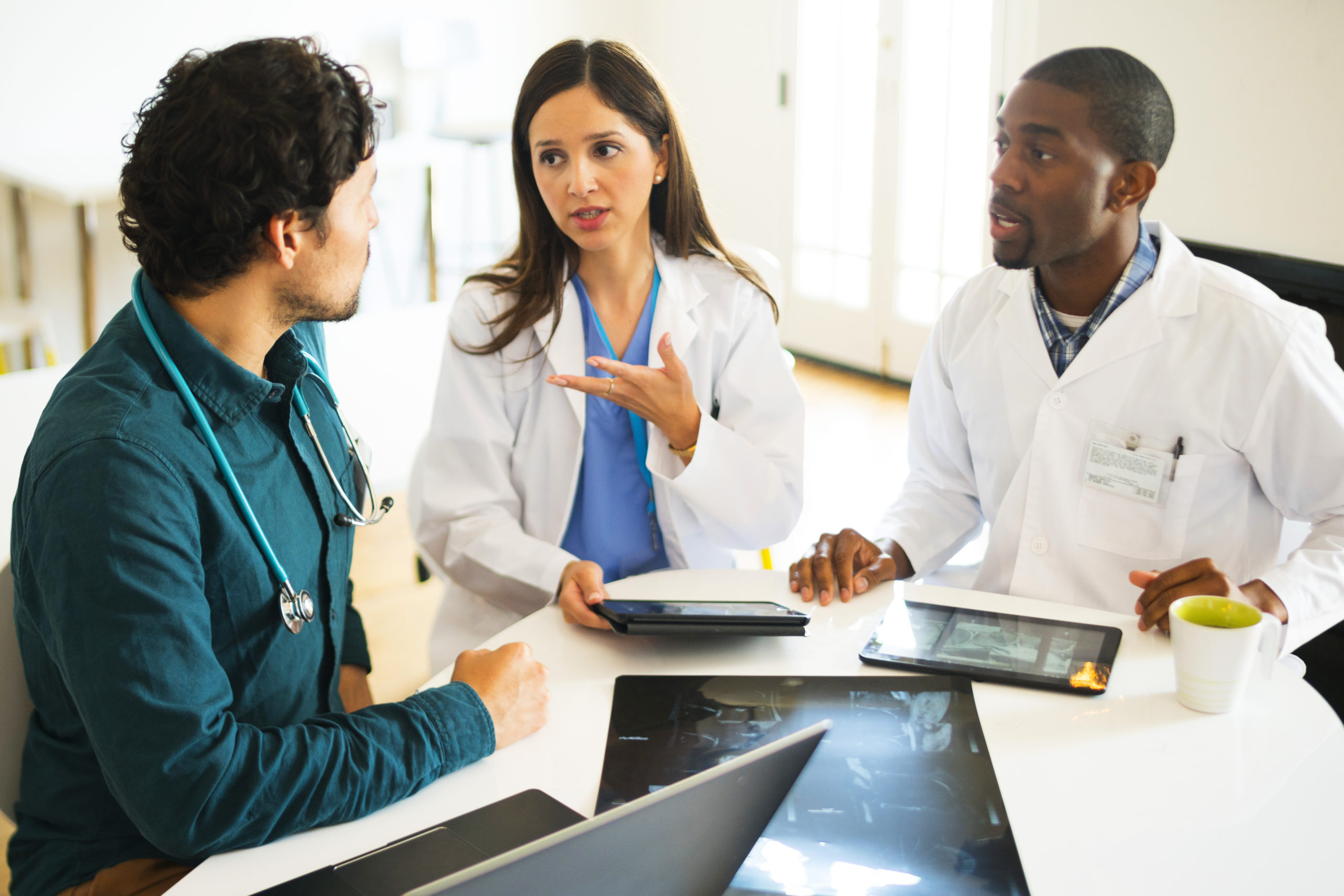 Doctors talking together with digital tablets and X-rays.