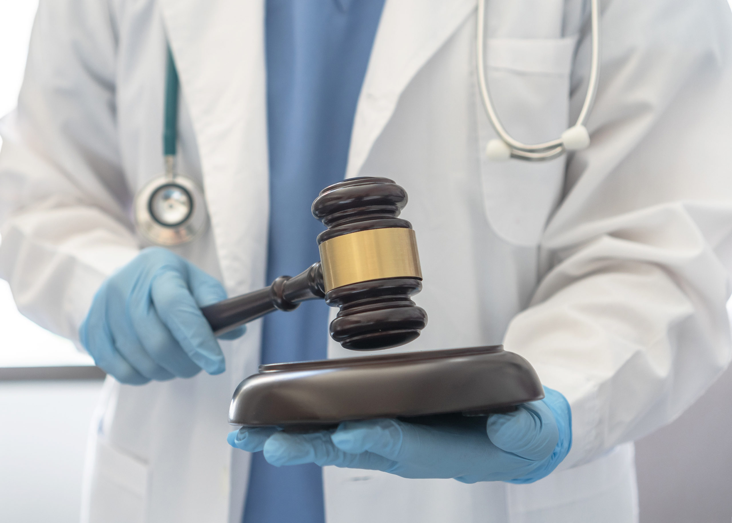 Forensic medicine, science or criminalistics legal investigation or medical practice - malpractice justice concept with judge gavel in hands of lab scientist or doctor for criminal and civil laws