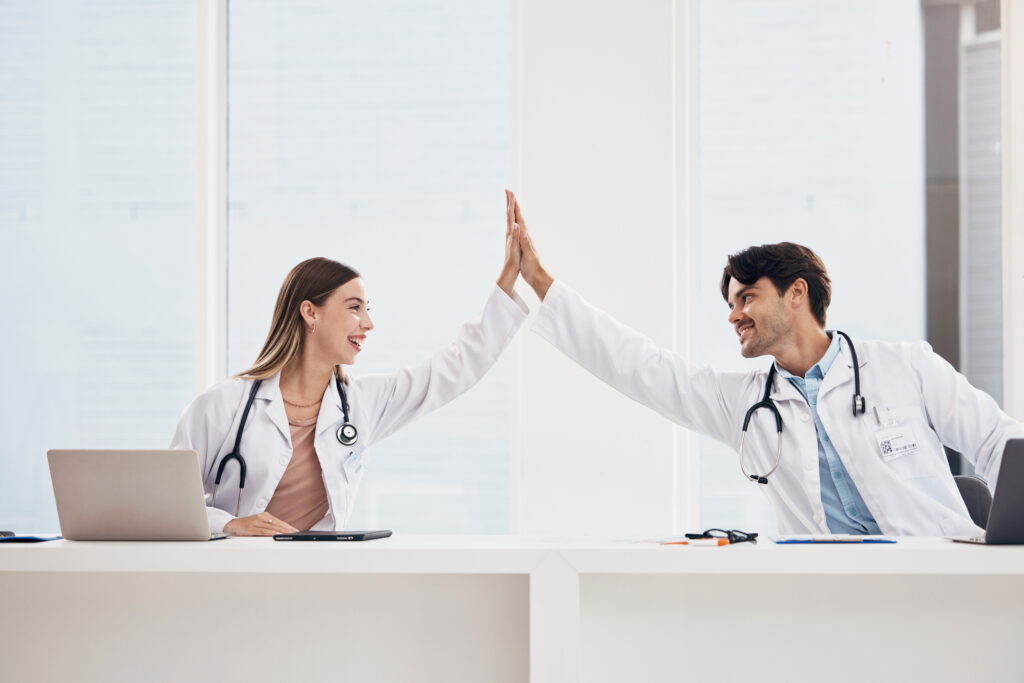 Success, high five or doctors in meeting for a strategy, goals or working in hospital for healthcare together. Man, happy woman or excited surgeons with nursing target, medical mission or teamwork