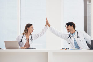 Success, high five or doctors in meeting for a strategy, goals or working in hospital for healthcare together. Man, happy woman or excited surgeons with nursing target, medical mission or teamwork