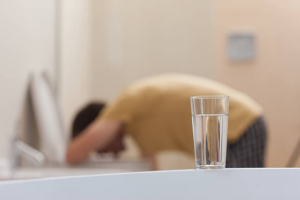 Man hunched down on toilet vomiting