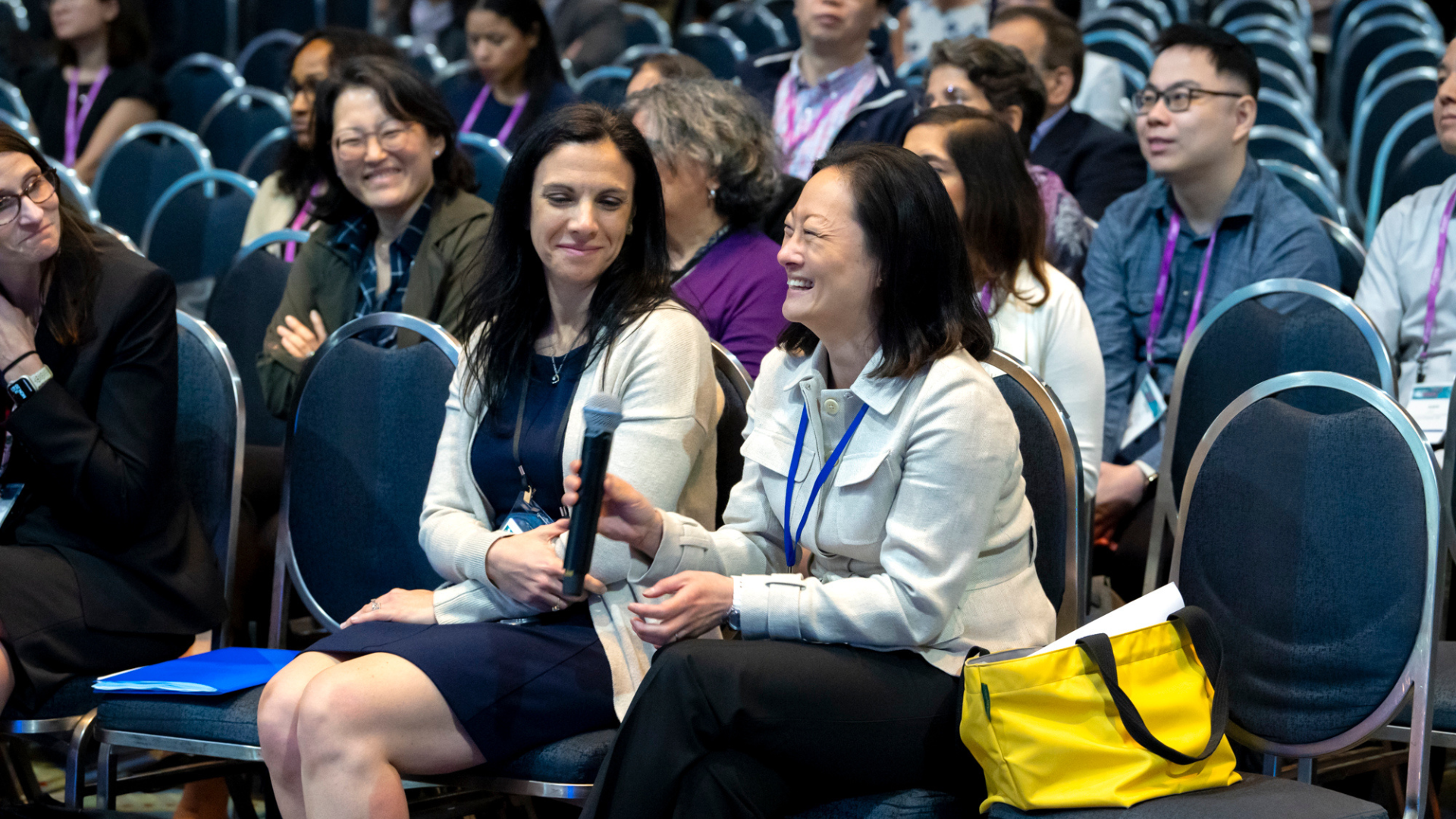 Woman holding microphone in session audience at DDW.