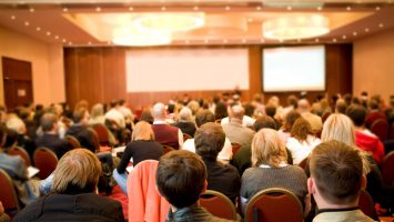Report Rear view of many listeners sitting on chairs during lecture at conference