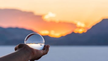 Bonneville Salt Flats colorful landscape bokeh background with hand holding crystal ball near Salt Lake City, Utah and mountain view and sunset Bonneville Salt Flats colorful landscape bokeh background with hand holding crystal ball near Salt Lake City, Utah and mountain view and sunset