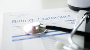 Health care billing statement with stethoscope, bottle of medicine for doctor's work in medical center stone background.