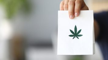 Courier hand passing package with marijuana