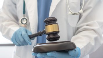 Forensic medicine, science or criminalistics legal investigation or medical practice - malpractice justice concept with judge gavel in hands of lab scientist or doctor for criminal and civil laws