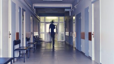 Blurred silhouette of a man passing away through the hospital hallway. The concept of problems of recovery and exit from the clinic