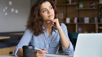 Young woman thinking at computer