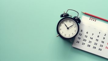 close up of calendar and alarm clock on the green background, planning for business meeting or travel planning concept close up of calendar and alarm clock on the green background, planning for business meeting or travel planning concept
