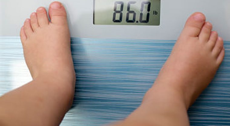 Overweight child on weighing machine